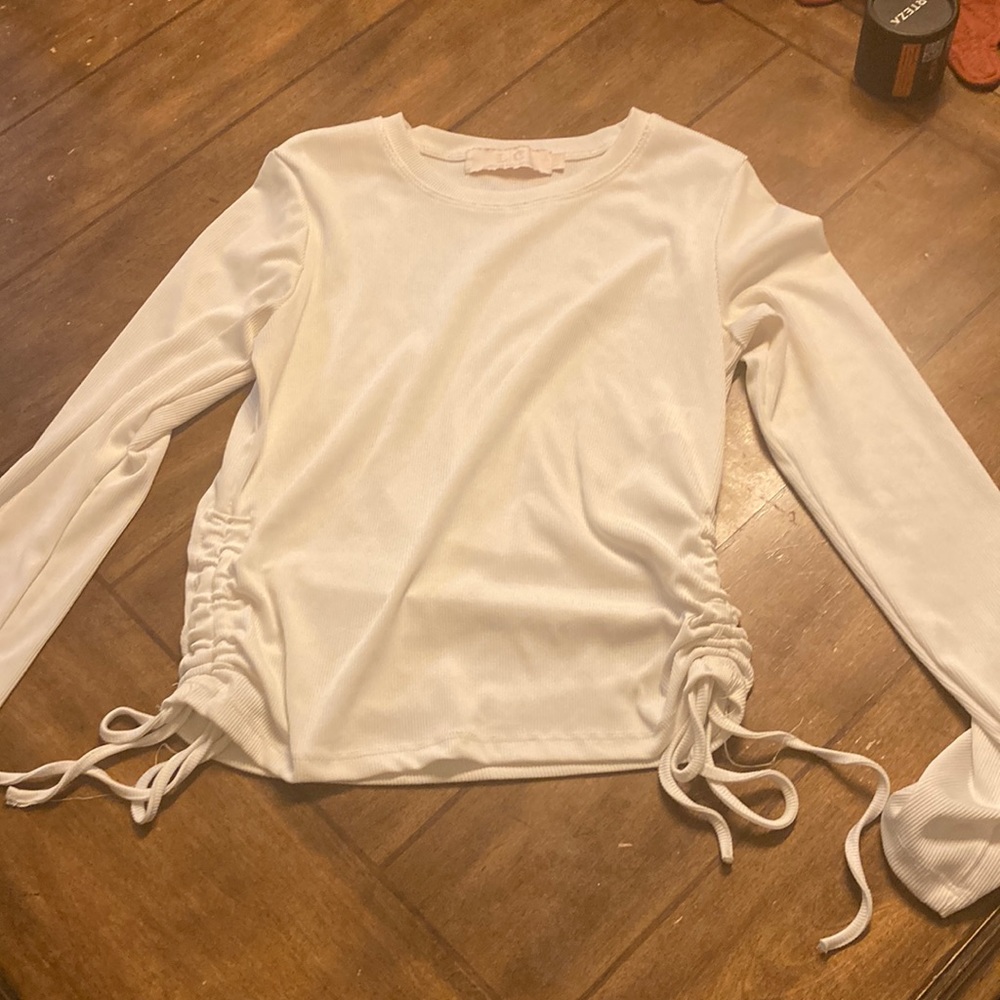 White long sleeve. Warn once. Sinched on the sides smoke free home.